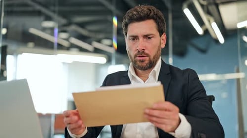 Stressed Businessman Reads Worrying Office Documents