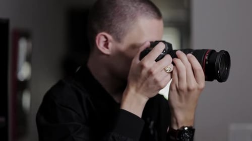 Young Man Using Digital Camera Indoors