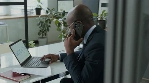 Adult in Suit Works at Desk in Office