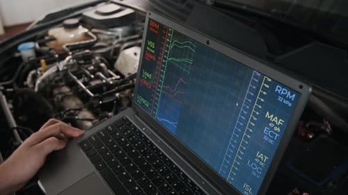 Laptop Displays Car Engine Diagnostics Data During Car Repair