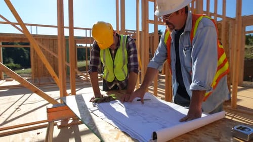 Bauarbeiter schauen sich gemeinsam Pläne an Architektur