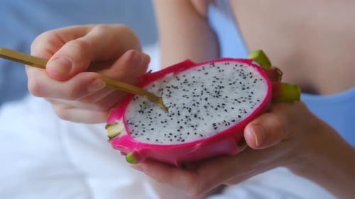 Woman Enjoys a Dragon Fruit with Spoon