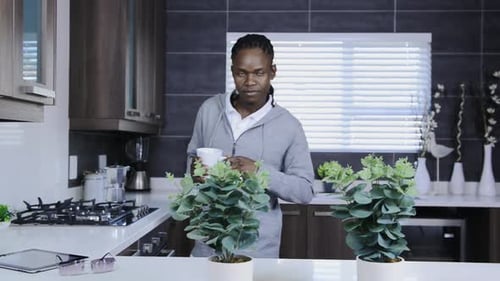 Smiling Man Drinking Coffee in Modern Kitchen