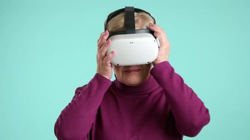 Excited Smiling Elegant Senior Woman Putting on Virtual Reality Headset Studio