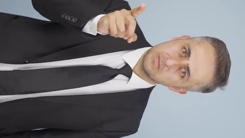 Vertical video of Businessman alerting camera with stern expression.