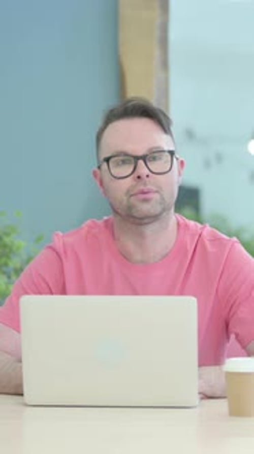 Man Typing on Laptop at Desk Indoors Portrait