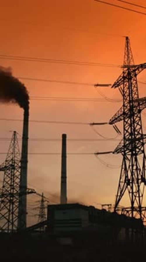 Power Plant Silhouetted at Dusk with Smoke