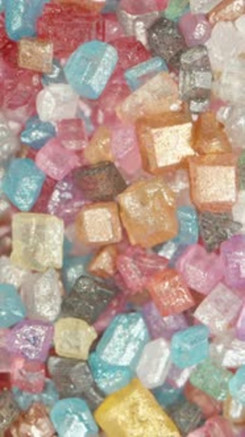 Vertical video. Top View of Rainbow Sugar Particles, Concept of a Beautiful and Sweet Life. Dolly.