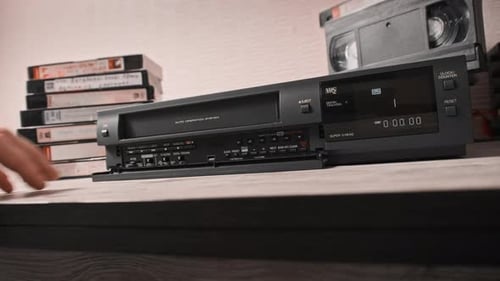 Pulls Out VHS Tape Cassette From a Vintage VCR Recorder