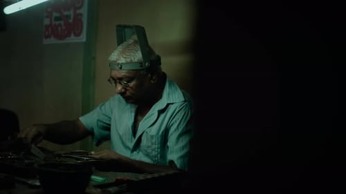 Man Working at Bench in Dimly Lit Workshop