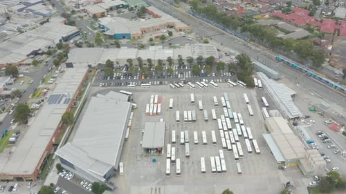 Aerial perspective fly over tracking toward and over bus depot.