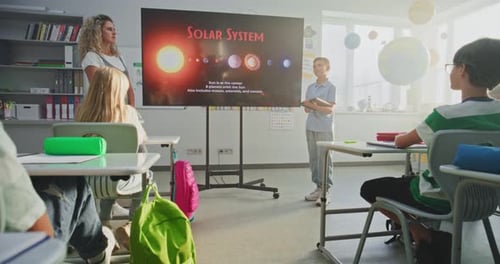 Primary School Boy Showcasing Knowledge of Astronomy in Front of Class and Teacher Using Digital