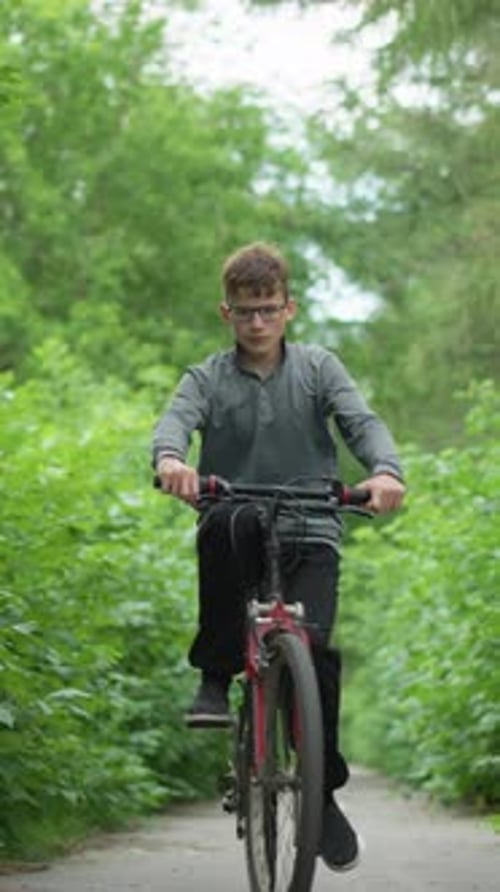 Young Boy Riding Bicycle Through Scenic Green Tunnel Surrounded By Lush Foliage