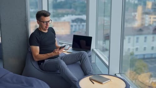 Man Relaxing With Technology in Modern Workplace