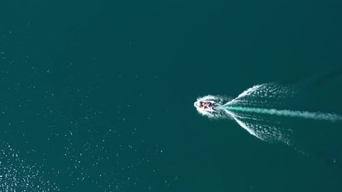 Aerial top down of a group of people sailing in a motorboat across Puelo Lake, Patagonia Argentina.