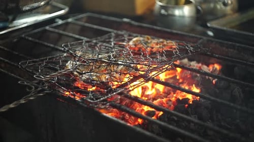 Fisch durch Braten auf Holzkohle garen. Verbrannter Fisch auf Barbecue-Grill