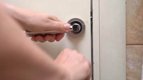 Hand opens and closes a door with silver handle