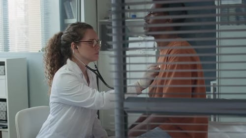 Doctor Listens to Patient with Stethoscope in Clinic