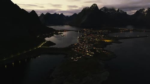 Picturesque Coastal Village Nestled Among Dark Mountains at Night