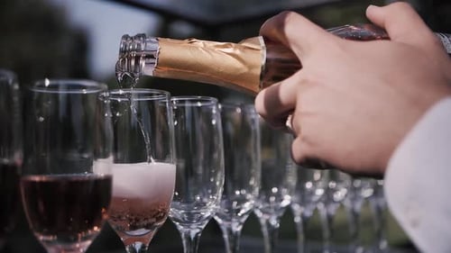 Pouring Rose into Champagne Glasses for Wedding