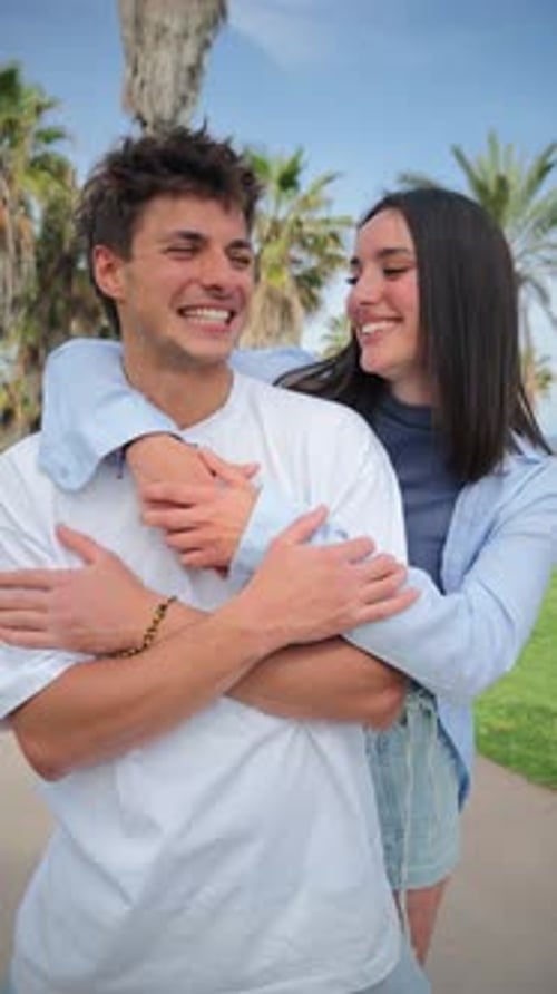 Smiling Couple Embracing Near Palm Trees