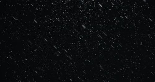 Winterschneefall in der Nacht schneit auf der Stadtstraße im Straßenlicht. Schneeflocken fallen in Zeitlupe