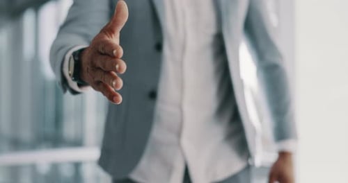 Hand Offering Handshake in Bright Office Setting