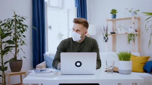 Man Working at Home Office with Mask