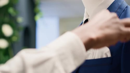 Worker Adds Pocket Square on Mannequin