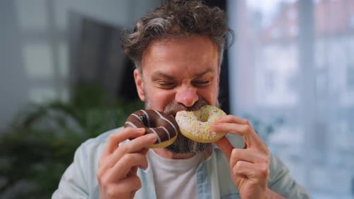 A Man Eating Two Donuts with Pleasure and at the Same Time Binge Eating Concept
