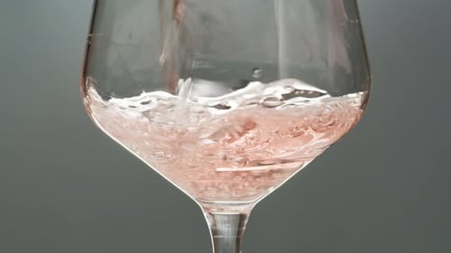 Orange or White Wine Bottle and Glass Against a Sunset in a Peaceful Vineyard Pouring of Ecological