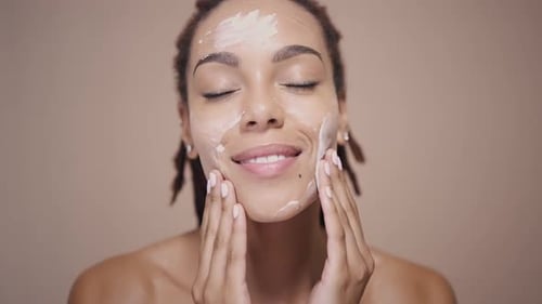 Woman Applies Cream to Her Face
