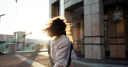 Feliz, mujer, bailando y ciudad por la mañana con sol, felicidad y celebración del bienestar