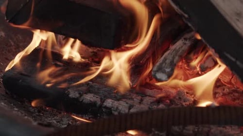 Nahaufnahme von Flammen im Kamin und glühender Glut in Zeitlupe
