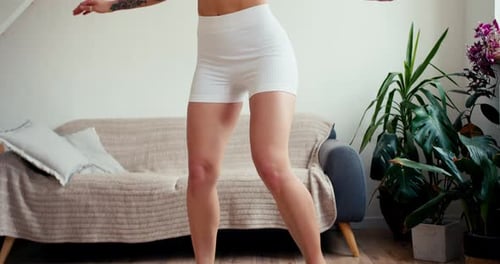 Closeup Shot a Girl in a Blue Suit Trains Her Balance on a Special Simulator in a Sunny Room