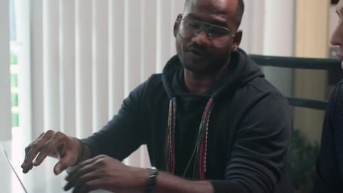 Men Collaborating on Laptop in Modern Office