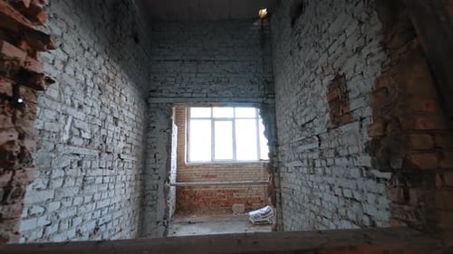 Shabby interior of an old house. White brick walls are newly-built in the premise.