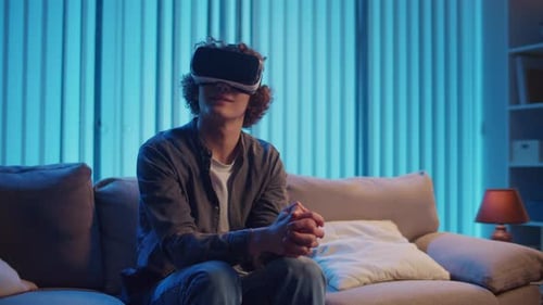 Young Adult Experiencing Virtual Reality Headset on Sofa