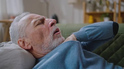 Senior Man with Gray Hair Lying on Couch