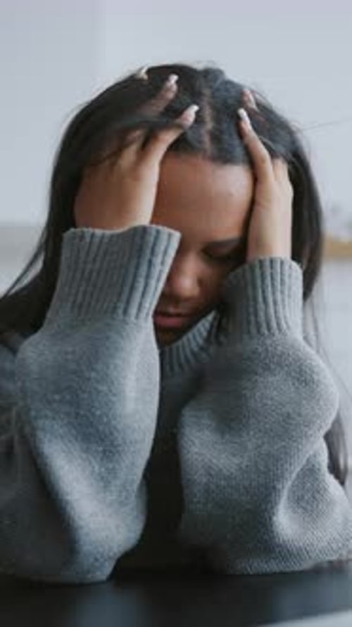 Exhausted Woman Holding Head and Looking at Laptop Display Portrait at Home Young Black Female