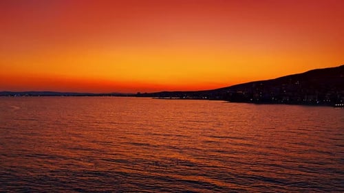 Iconic sunset over the seascape. Some birds float on the water surface.