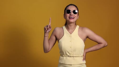 Excited Woman Showing Off New Sunglasses In Studio