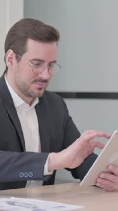 Man in Suit Using Tablet at Office Desk