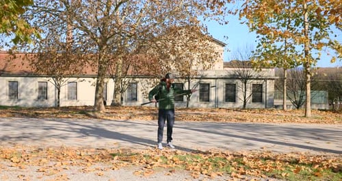 Homem estendendo o bastão de selfie da câmera de ação Insta360 X4 ao ar livre durante o outono em Lucca, Itália.
