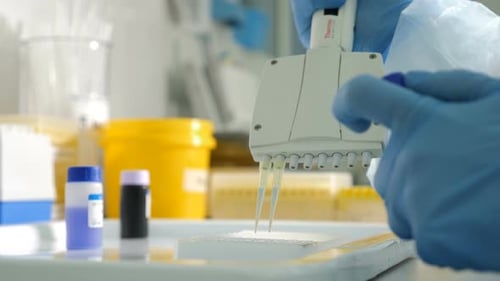 Medical Professional Pipetting Liquid in Brightly Lit Lab