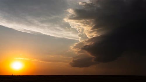 Powerful Storm Clouds Rising Into The Atmosphere As The Sun Sets