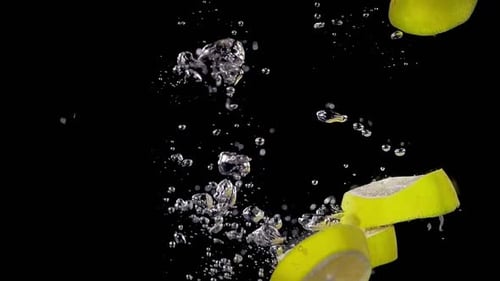 Sliced Lemons Splashing into Water on Black Background