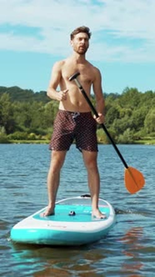 A Man Enjoys Paddleboarding on the Lake A Perfect Summer Adventure Awaits Him Ahead