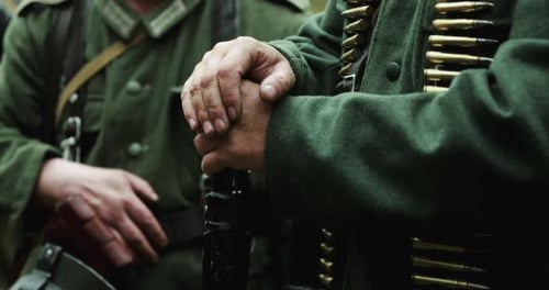 Nahaufnahme der Hände eines als Maschinengewehrschützen verkleideten Reenactors der deutschen Wehrmacht, Infanteriesoldat