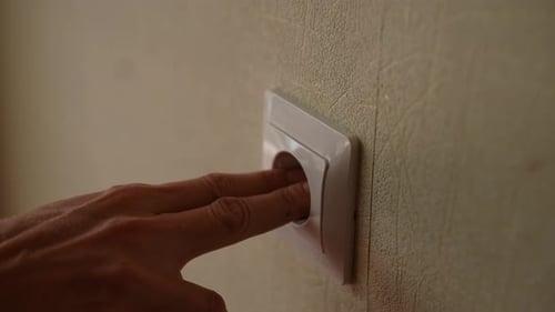 Closeup of Unrecognizable Man Inserting His Fingers Into an Electrical Outlet Showcasing Dangers of